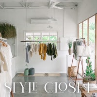 a white room with clothes hanging on racks and a sign that says style closet